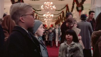 Movie still from “A Christmas Story” (1983), directed by Bob Clark – A group of people standing in front of christmas decorations; Medium shot, Low angle