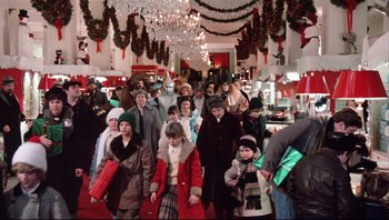Movie still from “A Christmas Story” (1983), directed by Bob Clark – A group of people walking down a red carpet in a store; Wide shot, High angle