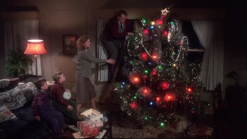 Movie still from “A Christmas Story” (1983), directed by Bob Clark – A group of people standing around a christmas tree; Wide shot, Low angle