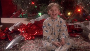 Movie still from “A Christmas Story” (1983), directed by Bob Clark – A young boy sitting in front of a christmas tree; Medium shot, High angle