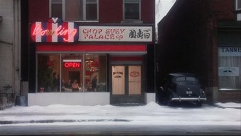 Movie still from “A Christmas Story” (1983), directed by Bob Clark – A car parked in front of a restaurant on a snowy day; Extreme Wide shot, High angle