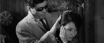 Movie still from “A Colt Is My Passport” (1967), directed by Takashi Nomura – A man and a woman are touching each other's hair; Close Up shot, Over the shoulder angle