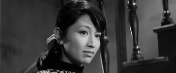 Movie still from “A Colt Is My Passport” (1967), directed by Takashi Nomura – A black - and - white photo of a young woman; Close Up shot, Over the shoulder angle