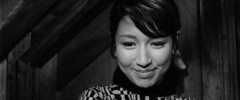 Movie still from “A Colt Is My Passport” (1967), directed by Takashi Nomura – A person smiling for the camera; Close Up shot, High angle