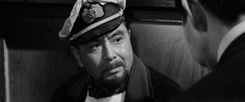 Movie still from “A Colt Is My Passport” (1967), directed by Takashi Nomura – A man wearing a hat and a scarf; Close Up shot, Over the shoulder angle