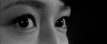 Movie still from “A Colt Is My Passport” (1967), directed by Takashi Nomura – A person's eyes in a black and white photo; Extreme Close Up shot, High angle