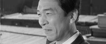 Movie still from “A Colt Is My Passport” (1967), directed by Takashi Nomura – An older asian man looking off into the distance; Close Up shot, Low angle