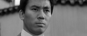 Movie still from “A Colt Is My Passport” (1967), directed by Takashi Nomura – Black and white photograph of a man's face; Close Up shot, Low angle