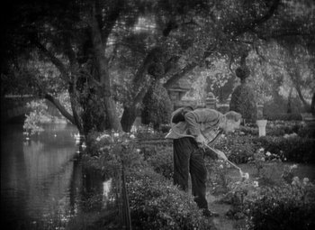 Movie still from “A Damsel in Distress” (1937), directed by George Stevens – A black and white photo of a man holding a fishing rod; Wide shot, High angle