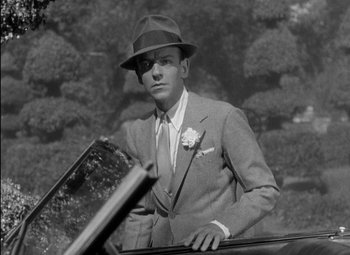 Movie still from “A Damsel in Distress” (1937), directed by George Stevens – A black and white photo of a man in a suit and hat; Close Up shot, Low angle