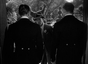 Movie still from “A Damsel in Distress” (1937), directed by George Stevens – A group of men standing next to each other in suits; Medium shot, Over the shoulder angle