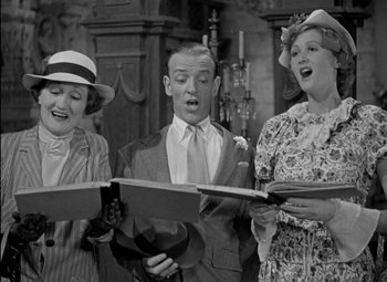 Movie still from “A Damsel in Distress” (1937), directed by George Stevens – A group of people singing in front of a mirror; Medium shot, Low angle