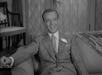 Movie still from “A Damsel in Distress” (1937), directed by George Stevens – A man in a suit sitting on a couch; Medium shot, High angle