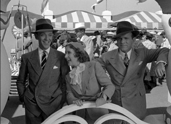 Movie still from “A Damsel in Distress” (1937), directed by George Stevens – A black and white photo of a man and two women; Medium shot, Low angle