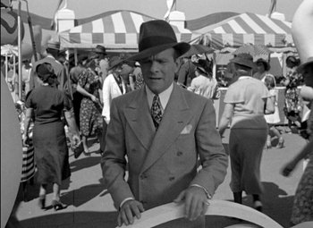 Movie still from “A Damsel in Distress” (1937), directed by George Stevens – An old photo of a man in a suit and hat; Medium shot, High angle
