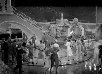 Movie still from “A Damsel in Distress” (1937), directed by George Stevens – A group of people dancing on a stage in front of a building; Extreme Wide shot, High angle