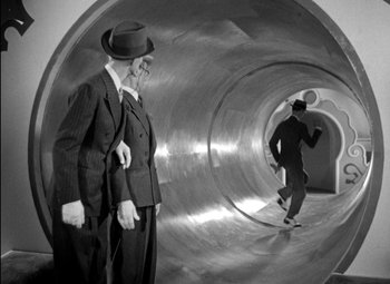 Movie still from “A Damsel in Distress” (1937), directed by George Stevens – A man in a suit and a hat standing next to another man in a suit and a hat; Wide shot, High angle