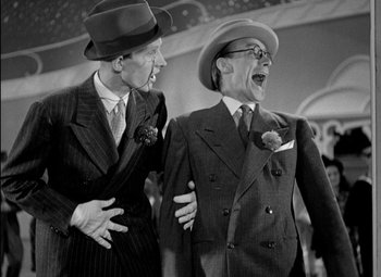 Movie still from “A Damsel in Distress” (1937), directed by George Stevens – A couple of men standing next to each other; Medium shot, Low angle