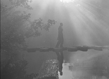 Movie still from “A Damsel in Distress” (1937), directed by George Stevens – A man walking across a bridge over a body of water; Wide shot, Low angle