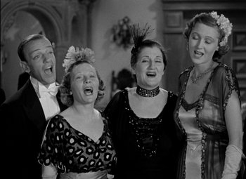 Movie still from “A Damsel in Distress” (1937), directed by George Stevens – A black and white photo of a group of people singing; Medium shot, Low angle