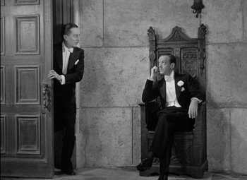 Movie still from “A Damsel in Distress” (1937), directed by George Stevens – Two men in tuxedos sitting on a chair; Medium shot, High angle