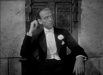 Movie still from “A Damsel in Distress” (1937), directed by George Stevens – A man sitting in a chair wearing a tuxedo; Close Up shot, Low angle