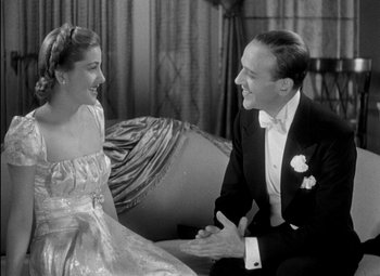 Movie still from “A Damsel in Distress” (1937), directed by George Stevens – A man and a woman sitting on a couch talking to each other; Medium shot, Low angle