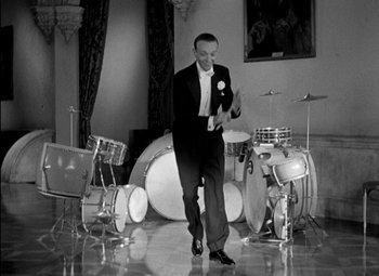 Movie still from “A Damsel in Distress” (1937), directed by George Stevens – A black and white photo of a man in a tuxedo; Medium shot, Low angle