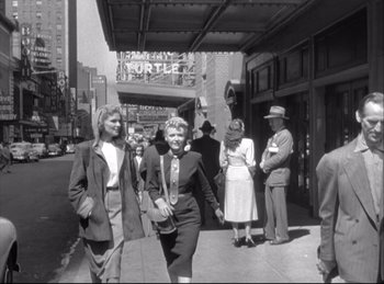 Movie still from “A Double Life” (1947), directed by George Cukor – A group of people walking down a street; Wide shot, Low angle