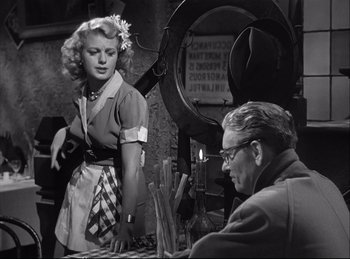 Movie still from “A Double Life” (1947), directed by George Cukor – A woman standing next to a man in a room; Medium shot, Low angle