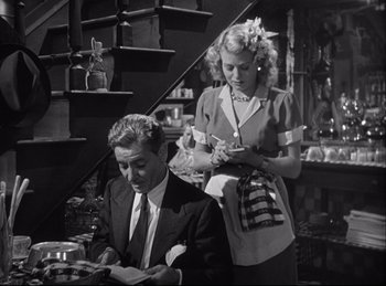 Movie still from “A Double Life” (1947), directed by George Cukor – A man and a woman are sitting at a table together; Medium shot, High angle