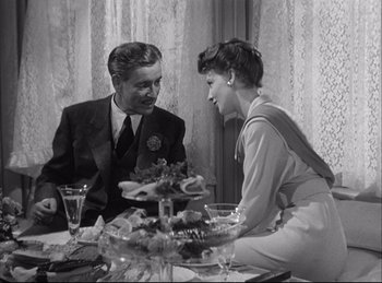 Movie still from “A Double Life” (1947), directed by George Cukor – An old photo of a man and a woman sitting at a dinner table; Medium shot, High angle