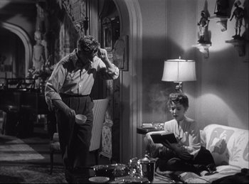 Movie still from “A Double Life” (1947), directed by George Cukor – A man and a woman sitting on a couch; Medium shot, Low angle