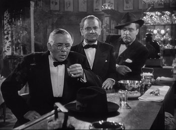 Movie still from “A Double Life” (1947), directed by George Cukor – A group of men sitting at a table in front of drinks; Medium shot, Over the shoulder angle