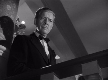 Movie still from “A Double Life” (1947), directed by George Cukor – Black and white photograph of a man in a suit and bow tie; Close Up shot, Low angle