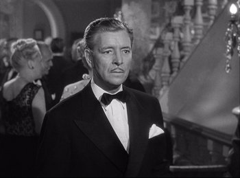 Movie still from “A Double Life” (1947), directed by George Cukor – A man in a suit and bow tie in front of a crowd; Medium shot, Over the shoulder angle