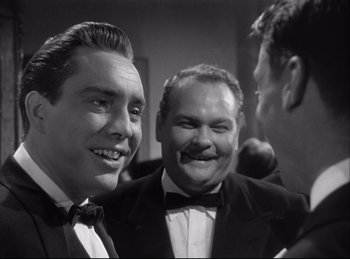 Movie still from “A Double Life” (1947), directed by George Cukor – A black - and - white photo of three men in tuxedos; Close Up shot, Over the shoulder angle