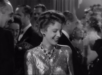 Movie still from “A Double Life” (1947), directed by George Cukor – An old photo of a woman smiling at a party; Medium shot, Over the shoulder angle