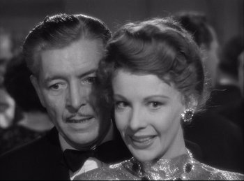 Movie still from “A Double Life” (1947), directed by George Cukor – An older man standing next to an older woman; Close Up shot, Low angle