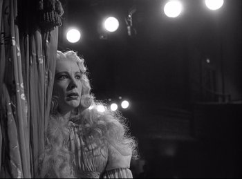 Movie still from “A Double Life” (1947), directed by George Cukor – A woman with long blonde hair standing in front of a curtain; Medium shot, Low angle
