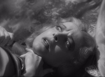 Movie still from “A Double Life” (1947), directed by George Cukor – A black and white photo of a woman laying on the ground; Close Up shot, Overhead angle