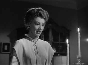 Movie still from “A Double Life” (1947), directed by George Cukor – A black and white photo of a woman standing next to a lit candle; Close Up shot, Low angle