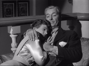 Movie still from “A Double Life” (1947), directed by George Cukor – An older man and a young woman are sitting together; Medium shot, Low angle