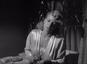 Movie still from “A Double Life” (1947), directed by George Cukor – A black - and - white photo of a woman in a silver dress; Close Up shot, Low angle