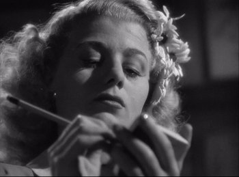 Movie still from “A Double Life” (1947), directed by George Cukor – A black - and - white photo of a woman holding a pencil; Close Up shot, Low angle