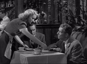 Movie still from “A Double Life” (1947), directed by George Cukor – An old photo of two men and a woman sitting at a dinner table; Medium shot, Over the shoulder angle