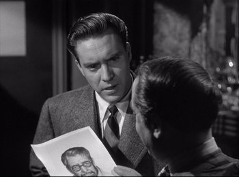 Movie still from “A Double Life” (1947), directed by George Cukor – A man and a woman looking at a picture of an old man; Close Up shot, Over the shoulder angle