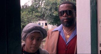 Movie still from “A Dry White Season” (1989), directed by Euzhan Palcy – A man and a woman standing next to each other; Close Up shot, Low angle
