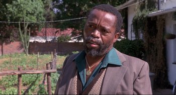 Movie still from “A Dry White Season” (1989), directed by Euzhan Palcy – A man with a beard wearing a suit and tie; Close Up shot, Low angle