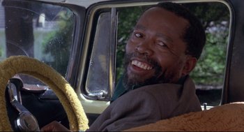 Movie still from “A Dry White Season” (1989), directed by Euzhan Palcy – A man sitting in the driver's seat of a truck; Close Up shot, Over the shoulder angle